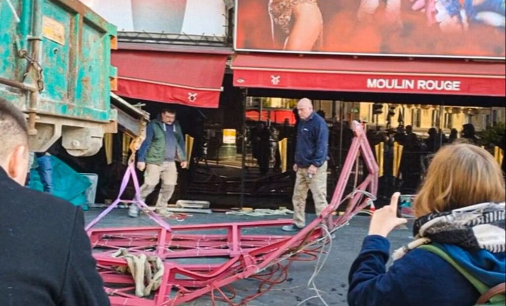 Caen las aspas del Moulin Rouge de París durante la noche