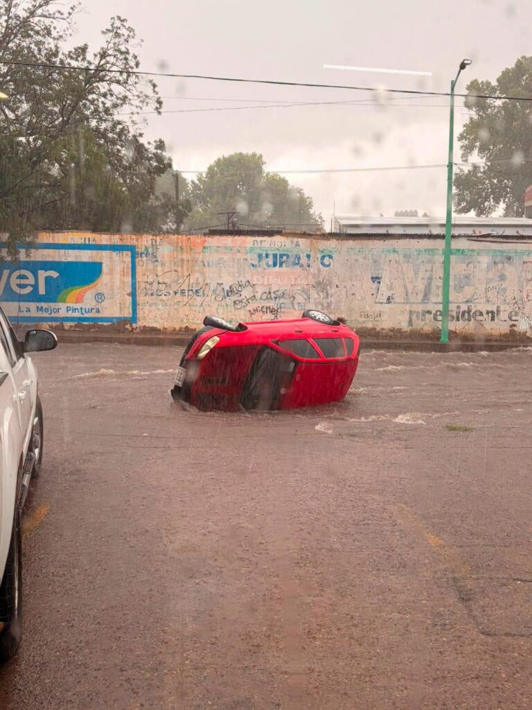 Vehículo es arrastrado por la corriente en la calle Víctor Hugo tras fuerte lluvia en Parral