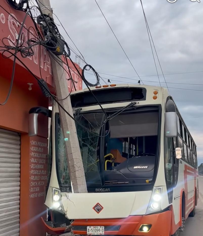 Poste de concreto y negocio de gorditas se le atraviesan a un autobús de ruta urbana